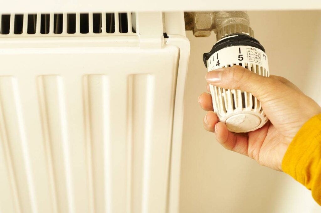 Kéz állítja a radiátor termosztátfejét